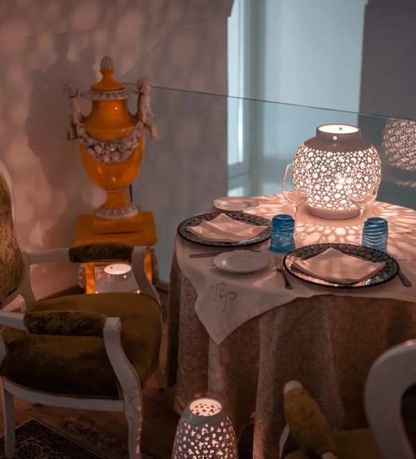 Dettaglio di tavolo per cena romantica con candele e decorazioni eleganti